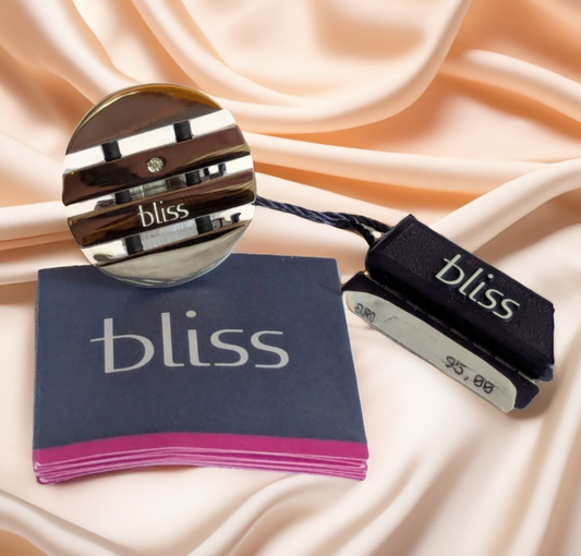 Bliss Damenring Edelstahl, Rund Vorderansicht mit Etikett auf Stoffuntergrund