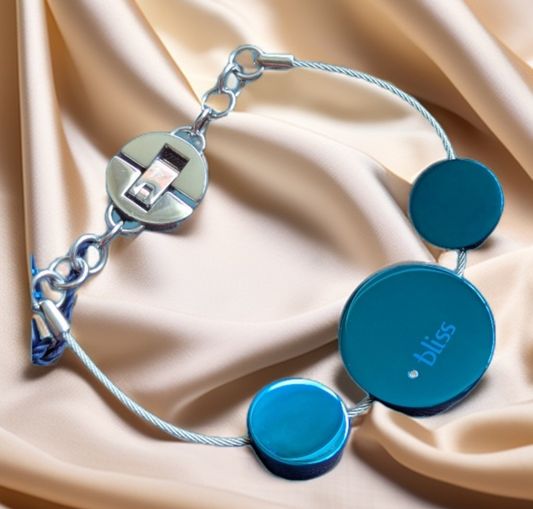 Bliss Damen Armband Edelstahl Kreise blau an Drahtseil Komplettansicht von vorne auf beigen Stoffuntergrund